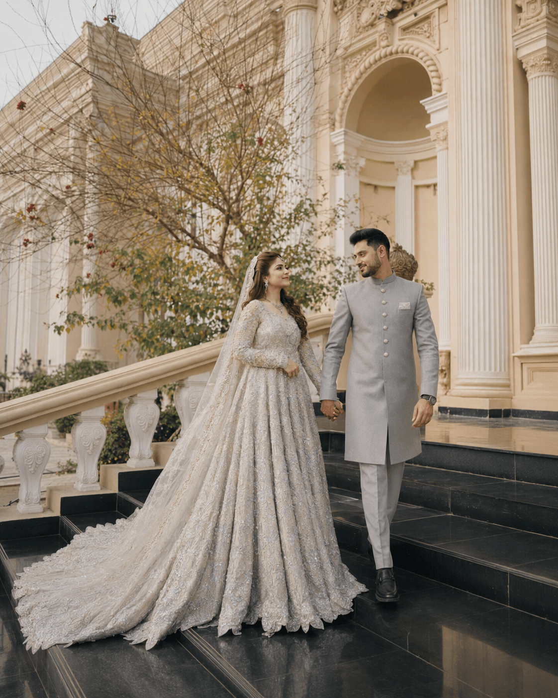 Couple walking on palace stairs in silver outfits